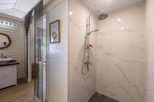 bagno con doccia e pareti in marmo di Opoa Beach Hotel a Opoa