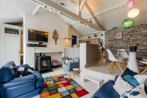 a living room with a blue couch and a fireplace at Le Cabanon Grand-Heid 2-4p in Lierneux
