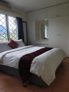a bedroom with a large bed and a large window at Homekey Apartments in Nadi