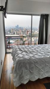 a bedroom with a bed and a large window at Grand Tower Del Valle in Mexico City