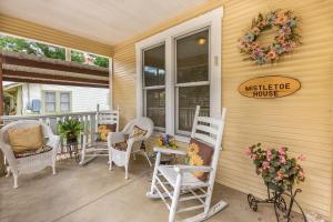 a porch with white rocking chairs and a house at Mistletoe House in Fredericksburg +13 photos