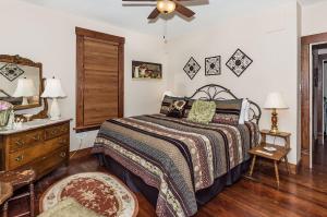a bedroom with a bed and a ceiling fan at Mistletoe House in Fredericksburg