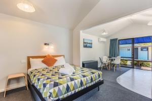 a bedroom with a bed and a table with chairs at Kaiteriteri Recreation Reserve Cabins in Kaiteriteri