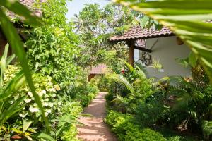 a path through a garden with green plants at La Mer Resort, Phú Quốc in Phú Quốc