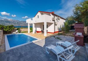 a villa with a swimming pool and a house at House Dali in Ražanac