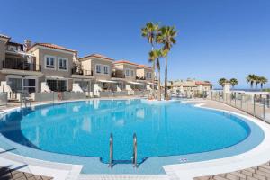 a large swimming pool with palm trees and houses at Apartment in Palm Mar - Insel Teneriffa 53099 in Palm-mar