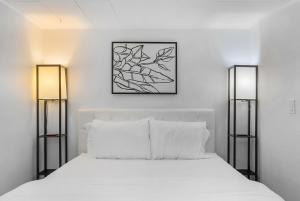 a bedroom with a white bed with two lamps at Green Lake Zen Garden Basement in Seattle
