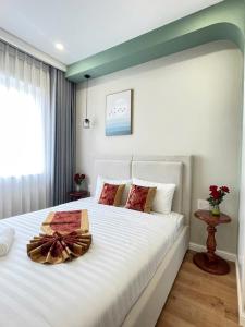 a bedroom with a large white bed with a bow on it at Villa IVY HOUSE in Bình Tú