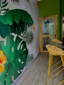 a room with a wall with a mural of leaves at Seven Nights Hostel Cartagena in Cartagena de Indias +91 photos