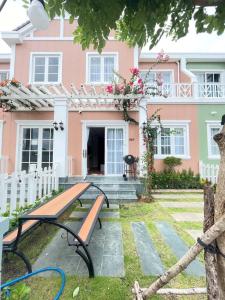 a pink house with a bench in front of it at Villa IVY HOUSE in Bình Tú +3 photos
