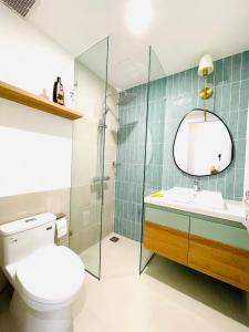 a bathroom with a toilet and a sink and a mirror at Villa IVY HOUSE in Bình Tú