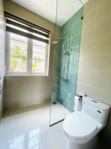 a bathroom with a toilet and a glass shower at Villa IVY HOUSE in Bình Tú +3 photos