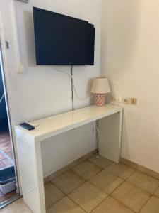 a desk with a television on top of it at Charmant Studio Vue Mer Village Soleil in Le Gosier