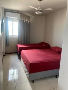 a bedroom with two beds and a window at Apartamento Maceió Maison Beira mar in Maceió
