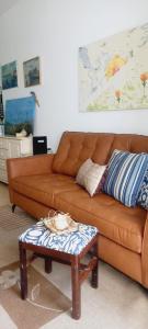 um sofá castanho numa sala de estar com uma mesa em Apartamento Enseada no Guarujá