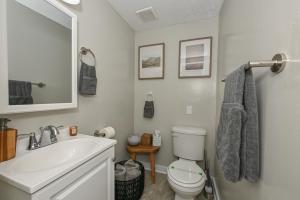 a bathroom with a sink and a toilet and a mirror at 3 Bed Spacious 1st Floor Apt at Tremont in Cleveland +36 photos