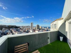 a balcony with a bench and a view of a city at Skyline Coruña in A Coruña