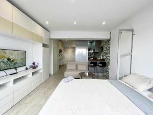 a bedroom with a large bed and a living room at Skyline Coruña in A Coruña
