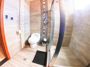 a small bathroom with a toilet and a shower at Hostal Dugan in Baños