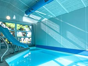 a swimming pool with a chair and a window at Strandblick - Dorf 1 Ferienhaus 21 in Priwall