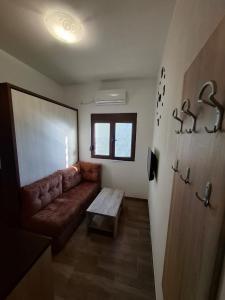 a living room with a brown couch and a table at Apartment Marija in Risan +12 photos