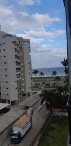 a truck parked in front of a building and the ocean at Apartamento a 50 metros da praia in Caraguatatuba