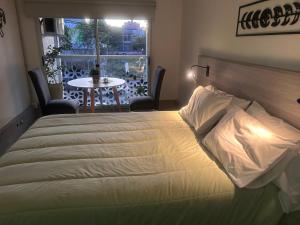 Cama en habitación con mesa y ventana en Apart Luro VI, en Santa Rosa