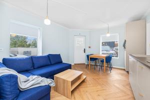 レイキャビクにあるDowntown Baldursbrá - Two Bedroom Apartmentの青いソファとテーブルのあるリビングルーム
