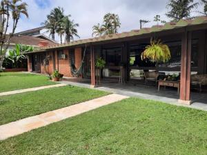 a house with a hammock in a yard at Casa na Marina com piscina churrasqueira e píer in Guarujá