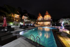 a house with a swimming pool at night at NG Sweet Home in Nusa Penida