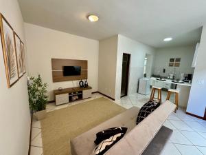 a living room with a couch and a tv at Estúdio no Centro de Nova Friburgo in Nova Friburgo
