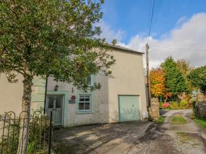 a small white house with a tree in front of it at John Duftons Barn in Cockermouth