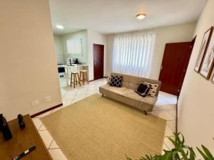 a living room with a couch and a kitchen at Estúdio no Centro de Nova Friburgo in Nova Friburgo