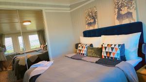 a bedroom with a bed with a blue headboard at Room In Handsome Haven House in Gjøvik