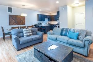 ein Wohnzimmer mit zwei blauen Sofas und einem Tisch in der Unterkunft TWO townhomes for your giant group! in Corvallis