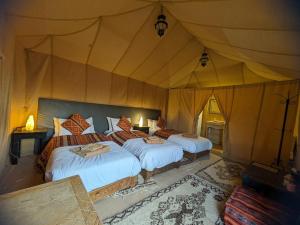 Postel nebo postele na pokoji v ubytování Erg Chebbi Romantic Desert Camp