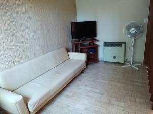 モンテ・エルモソにあるDepto Monte hermoso centroの白いソファと薄型テレビのあるリビングルーム