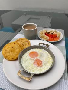 a plate of food with a fried egg and a cup of coffee at Hotel Quintas de Bogotá in Bogotá