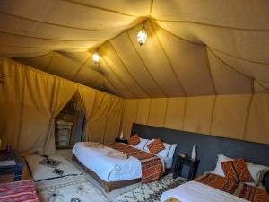 Postel nebo postele na pokoji v ubytování Erg Chebbi Romantic Desert Camp
