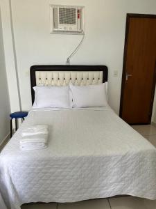 une chambre avec un lit avec deux serviettes dessus dans l'établissement Hospedagem 20m da praia., à Itapema