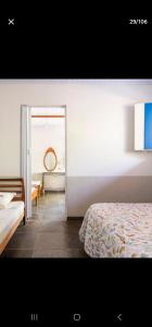 a bedroom with a bed and a mirror and a doorway at Estância Morro Do Frota in Pirenópolis