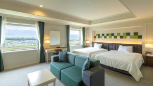 a hotel room with a bed and a couch at Hotel Kasugai in Fuefuki