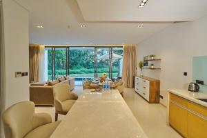 a kitchen and living room with a long wooden table at Clean & Quiet Villa - The Point Resort in Danang
