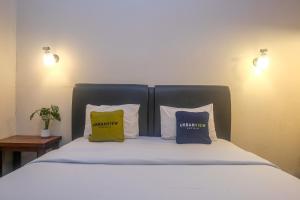 a bed with three pillows on it in a room at Urbanview Omah Pari Boutique Hotel in Yogyakarta