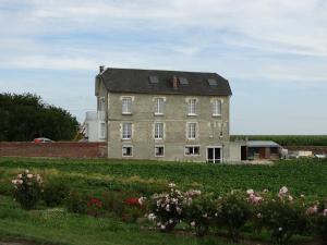 an old building in a field with flowers at Villa Jules Verne - Chambres d'hôtes et gîte in Bernes