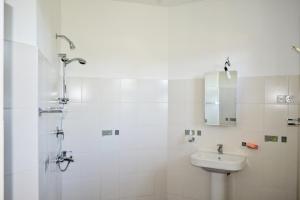ein weißes Badezimmer mit Waschbecken und Dusche in der Unterkunft Villa16Hikkaduwa in Hikkaduwa + 32 Fotos