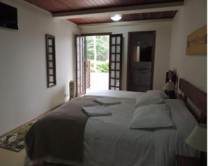 a bedroom with a large bed with pillows on it at Recanto Lucerna in Campos do Jordão +1 photo