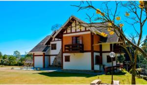 a house in the middle of a yard at Recanto Lucerna in Campos do Jordão