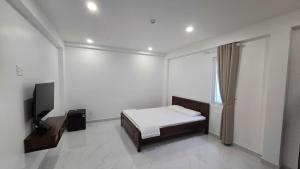 a bedroom with a bed and a flat screen tv at Hà Bảo Châu 2 Hotel Tân Bình in Ho Chi Minh City