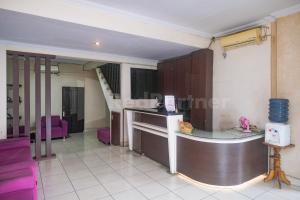 una camera con cucina con bancone e sedie viola di Bies Malioboro Hotel RedPartner a Yogyakarta